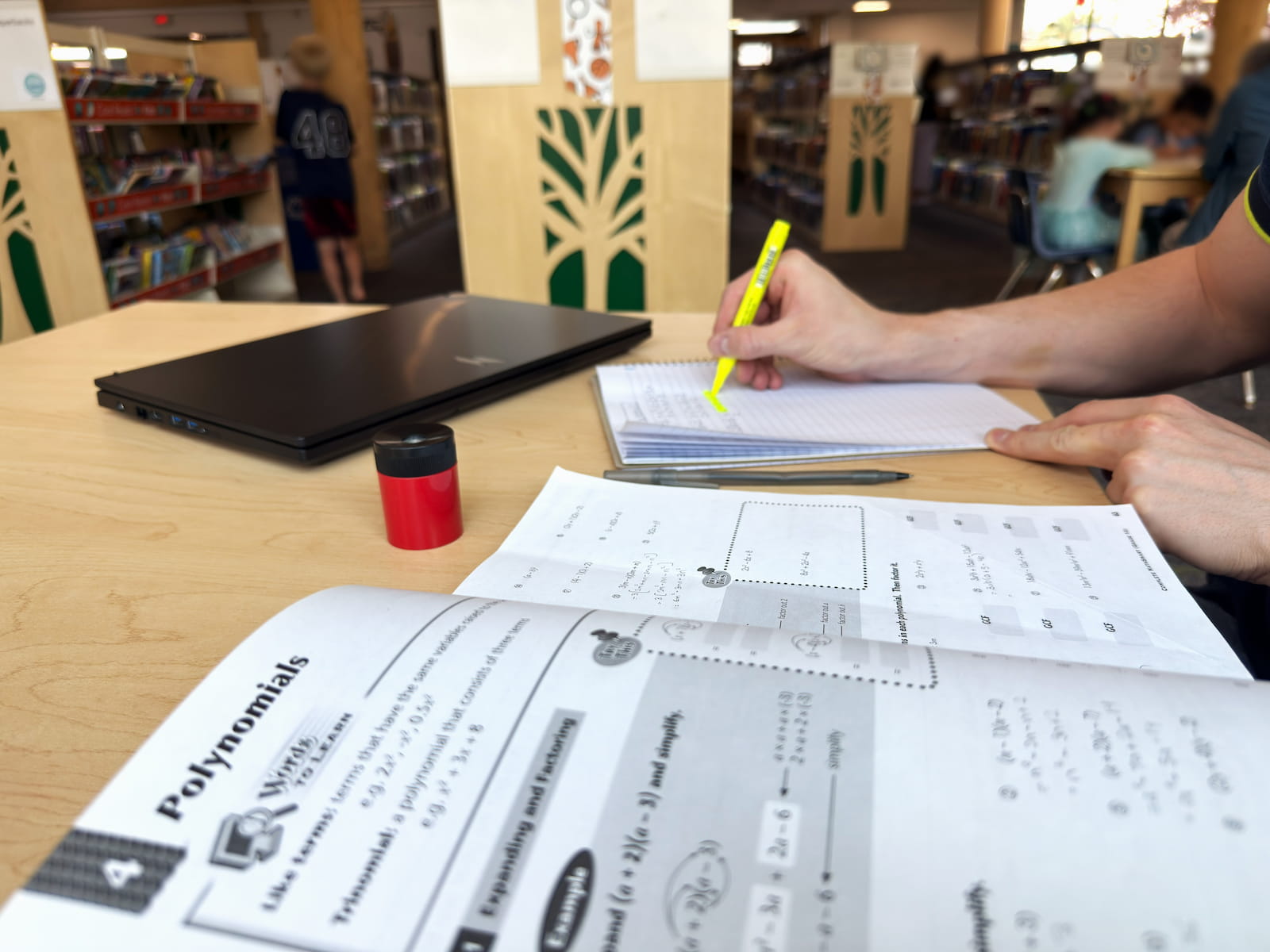 Working through a math problem with a student at a kitchen table in Calgary